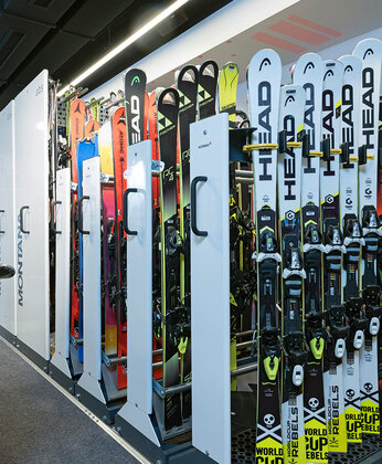 Innenraum eines Skiverleihs mit Ski- und Snowboardständern.